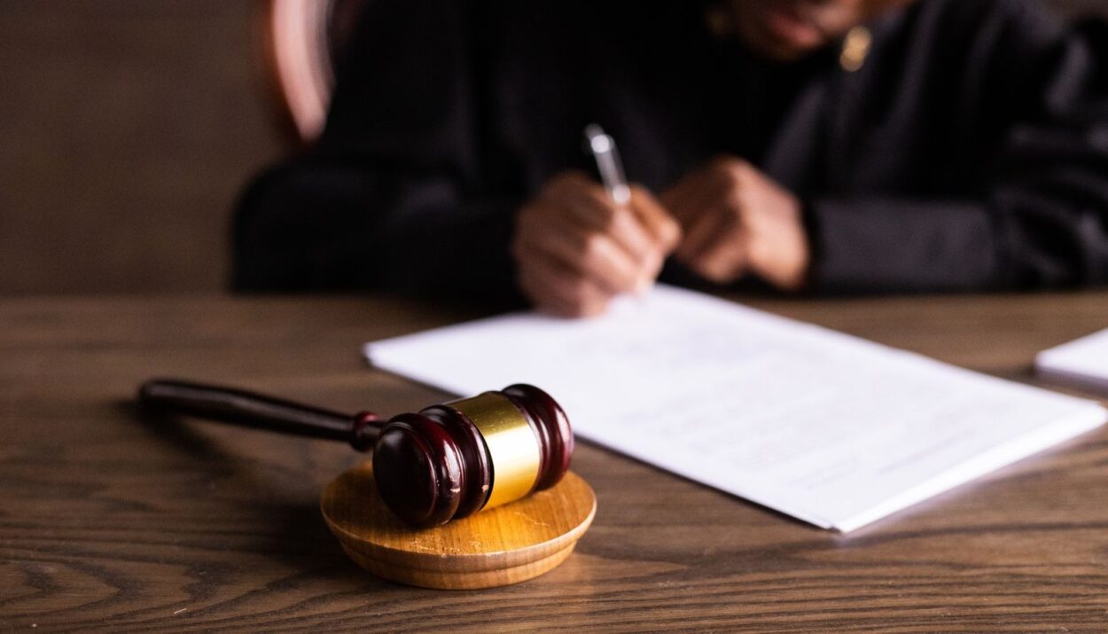Marteau de juge et signature de documents juridiques pour indemnisation du préjudice corporel