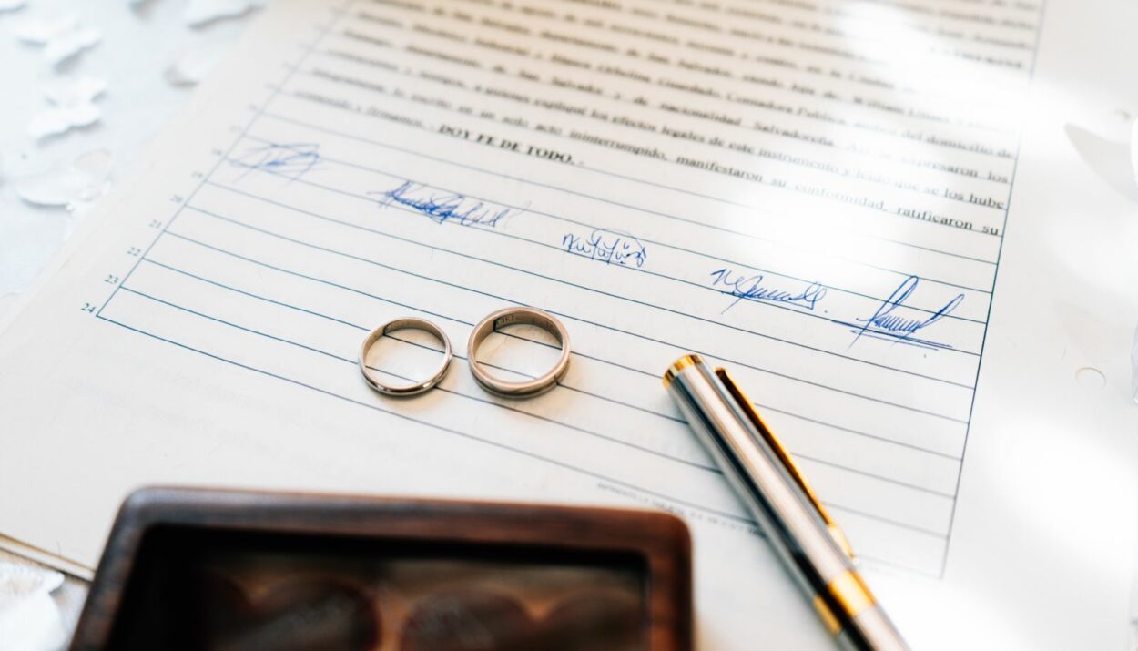 Alliances de mariage posées sur un contrat de mariage signé par les époux et un notaire
