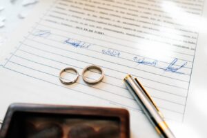 Alliances de mariage posées sur un contrat de mariage signé par les époux et un notaire