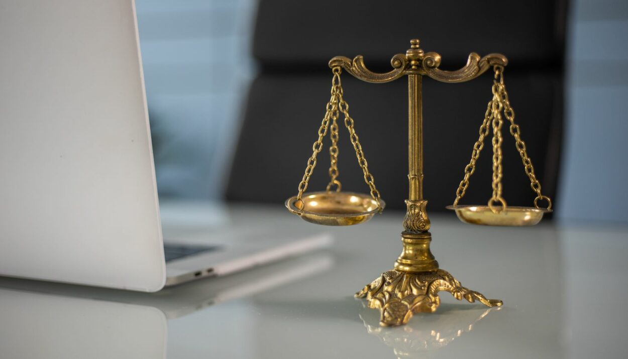 Balance de la justice devant un ordinateur portable, symbole du cyberharcèlement et de la sanction pénale