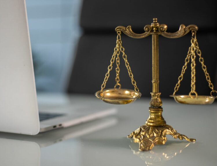 Balance de la justice devant un ordinateur portable, symbole du cyberharcèlement et de la sanction pénale