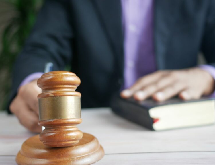 Marteau de justice sur un bureau à côté d'un livre de droit, illustration du recel